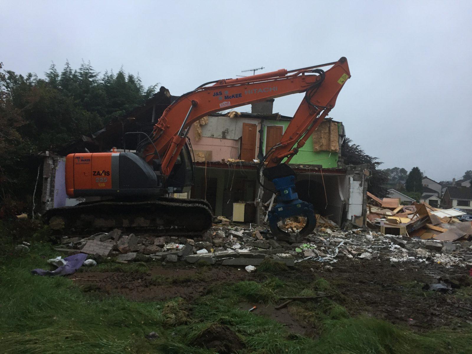 Demoliting existing buildings using grab on Excavator