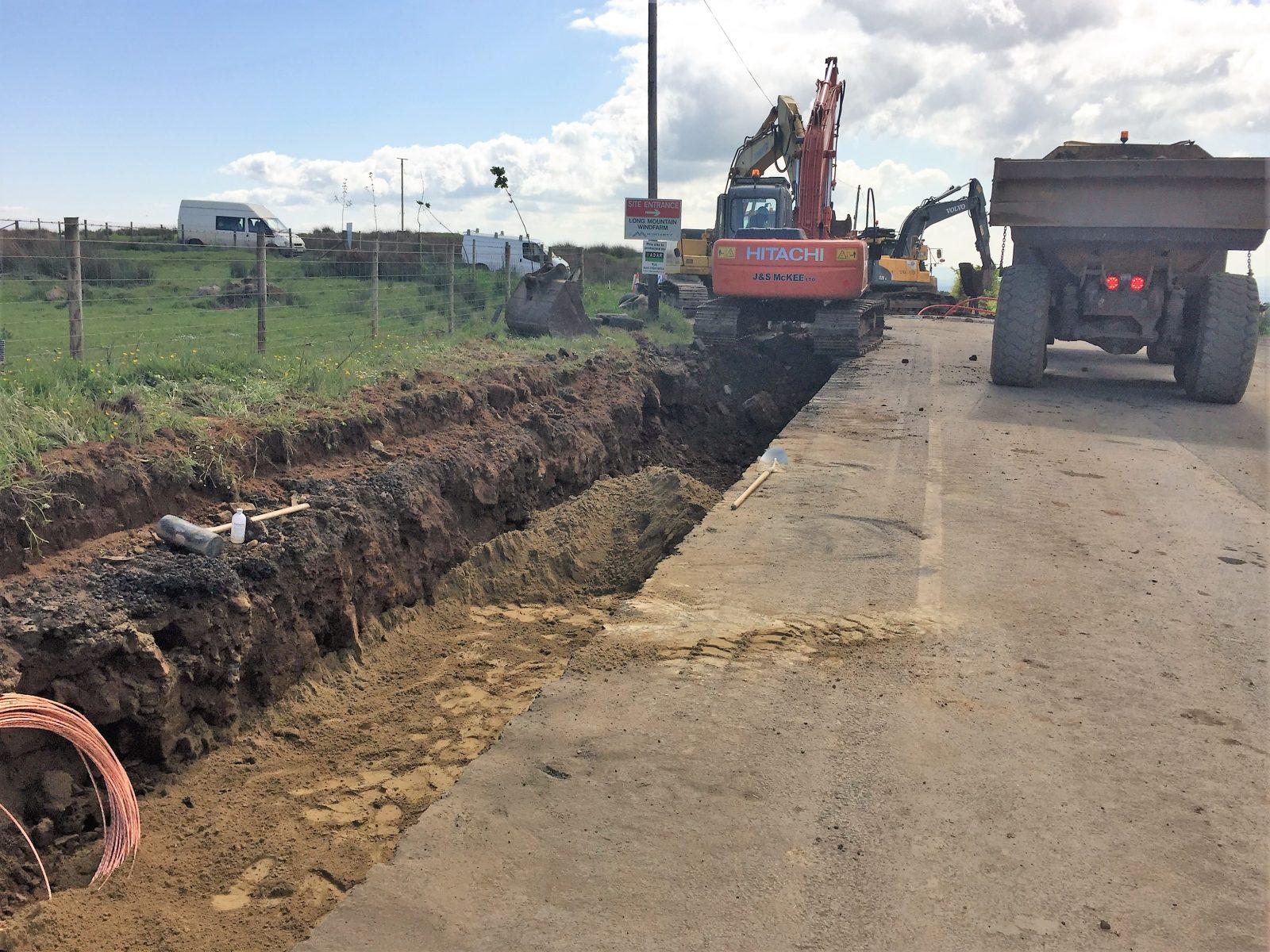 Digging trench for powerline on road to windfarm